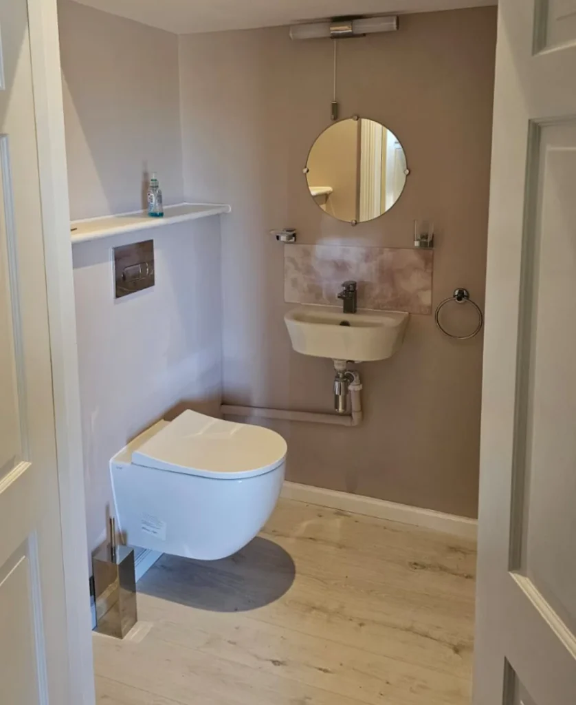 Finished cloakroom with wall-hung WC, basin and wood-effect flooring