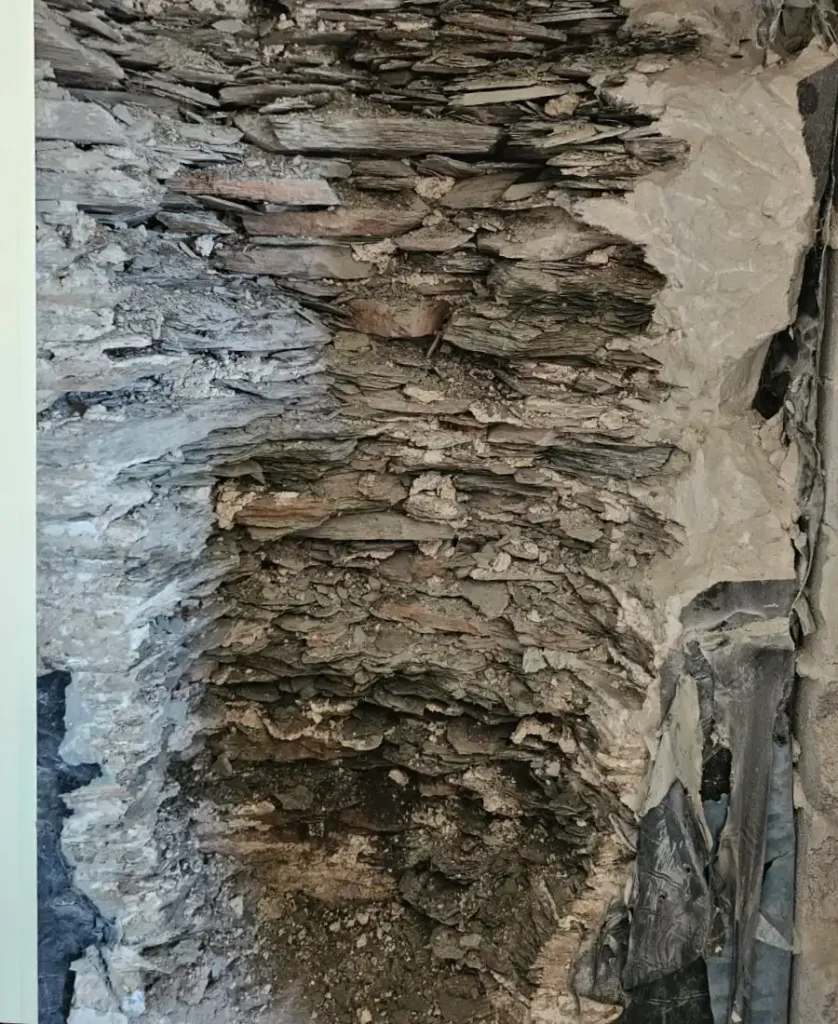 Exposed slate stone wall after old render and plaster were removed